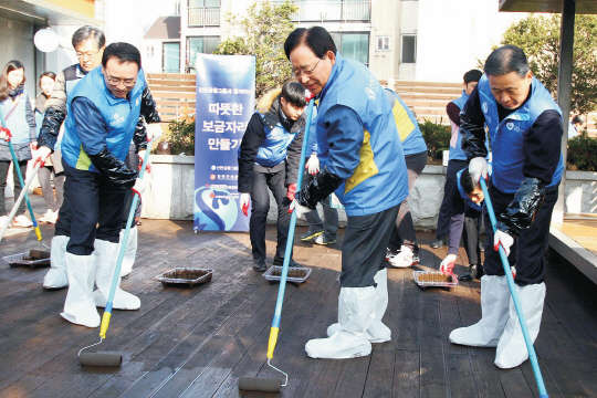 신한금융지주는 1일 서울 서대문구 북아현동 소재 서대문 장애인종합복지관에서 장애인들을 위한 '따뜻한 보금자리 만들기' 봉사활동을 실시했다. 한동우 회장(앞줄 왼쪽 두번째)이 조용병 신한은행장(첫번째), 이성락 신한생명 사장(세번째) 등 그룹사 CEO들과 함께 옥상정원에 부식방지를 위한 페인트 작업을 하고 있다.    신한은행 제공